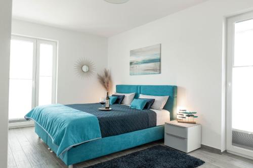 ein Schlafzimmer mit einem blauen Bett und einer weißen Wand in der Unterkunft Katamaran in Olpenitz