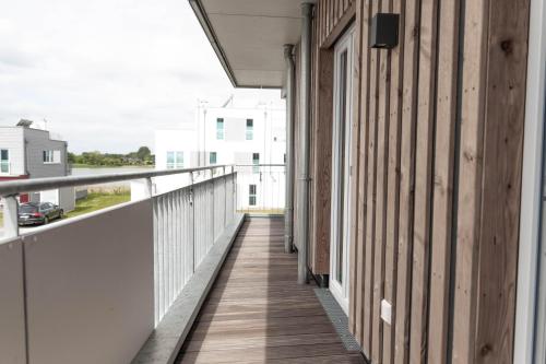 a balcony of a building with a wooden walkway at Katamaran in Olpenitz