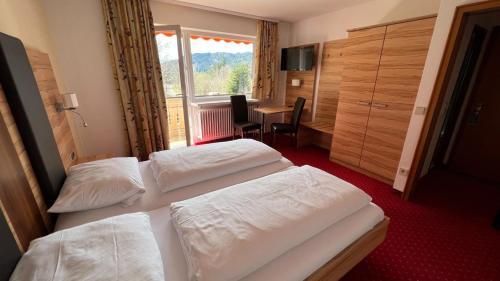 una camera d'albergo con due letti e un tavolo di Hotel Silberfelsen a Menzenschwand