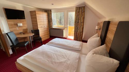 a hotel room with two beds and a table at Hotel Silberfelsen in Menzenschwand
