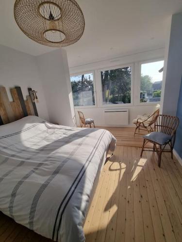 - une chambre avec un lit, des chaises et des fenêtres dans l'établissement Villa Marlilou-3 minutes à pied de la plage, à Merville-Franceville-Plage
