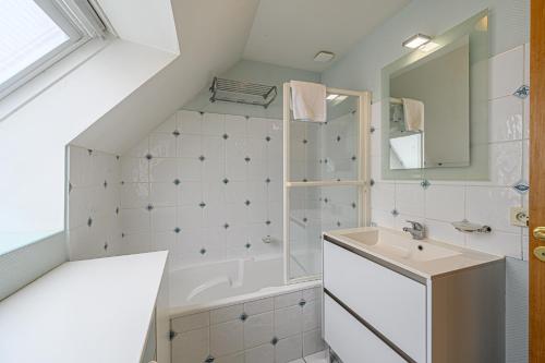 une salle de bain avec un lavabo et une baignoire dans l'établissement Althidis - Bel appt duplex sur le port de Vannes, à Vannes