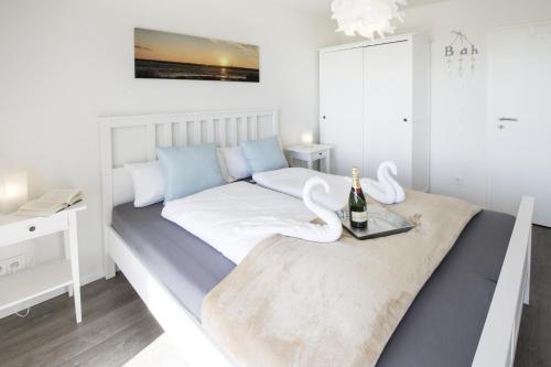 a white bedroom with a bed with swans on it at Ostseeliebe in Olpenitz