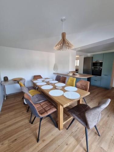 une table de salle à manger et des chaises dans une pièce dans l'établissement Villa Marlilou-3 minutes à pied de la plage, à Merville-Franceville-Plage
