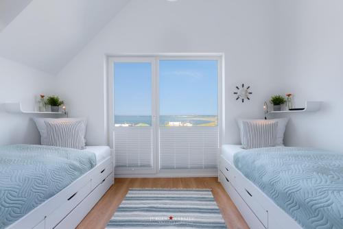 two beds in a room with a window at Seeadlerhorst in Olpenitz