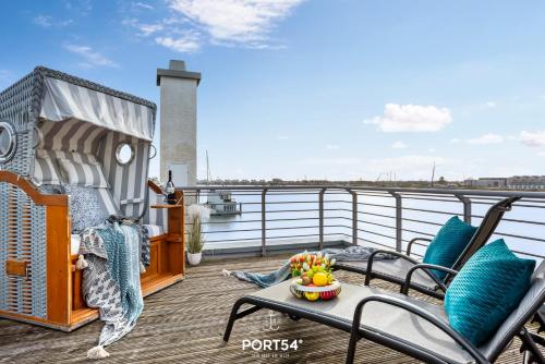 a balcony with chairs and a table with a bowl of fruit at SeaDream in Olpenitz