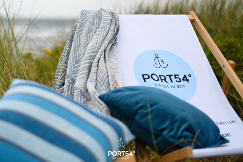 a book sitting next to two pillows on the beach at Lütthoorn in Olpenitz