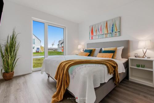 a bedroom with a bed and a large window at Blue Heaven in Olpenitz