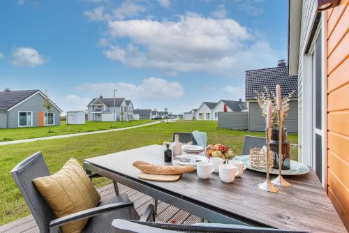 a table on a deck with a view of a yard at Blue Heaven in Olpenitz