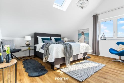 een slaapkamer met een bed en een blauwe stoel bij Fjordsegler in Olpenitz