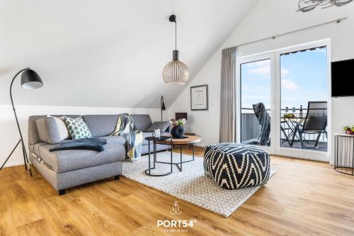 een woonkamer met een bank en een tafel bij Fjordsegler in Olpenitz