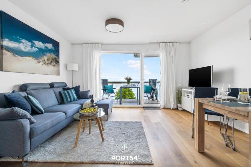 un soggiorno con divano blu e tavolo di Marina Sunset East a Olpenitz