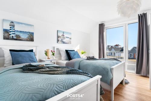 a bedroom with two beds and a large window at Port Seven in Olpenitz