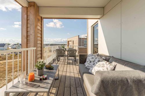 a balcony of a house with a couch on a deck at Gode Tied in Olpenitz
