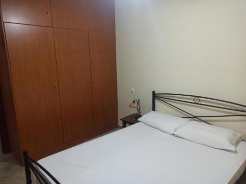 キオスにあるAvgonima Family's Roomsのベッドルーム1室(ベッド1台付)、木製キャビネットが備わります。
