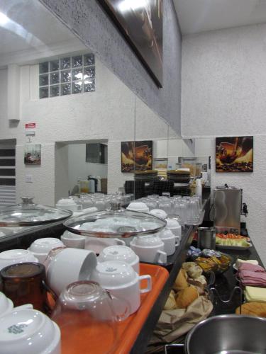 a kitchen with many plates and dishes on a counter at Hotel Tropicália próximo a 25 de março , Brás e Bom Retiro "Com estacionamento conveniado ao lado do hotel" in Sao Paulo