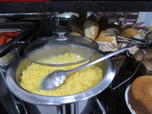 a pot of food on a stove with a spoon at Hotel Tropicália próximo a 25 de março , Brás e Bom Retiro "Com estacionamento conveniado ao lado do hotel" in Sao Paulo