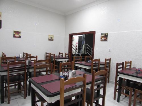 a dining room with wooden tables and chairs at Hotel Tropicália próximo a 25 de março , Brás e Bom Retiro "Com estacionamento conveniado ao lado do hotel" in Sao Paulo