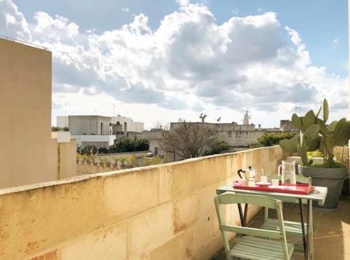 a table on a balcony with a view of a city at Wp Relais apartments in Diso