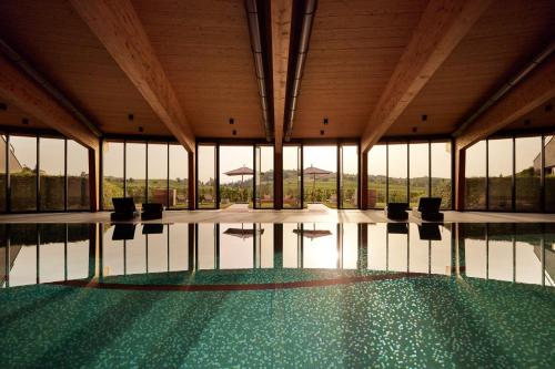 una piscina en un edificio con ventanas de cristal en Le Marne Relais, en Costigliole dʼAsti