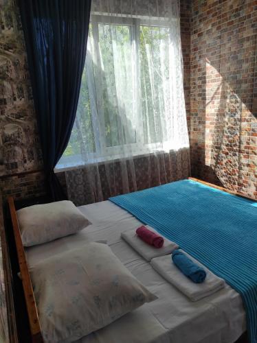 a bedroom with two beds with pillows and a window at Гостевой дом ИРИНА in Sukhum