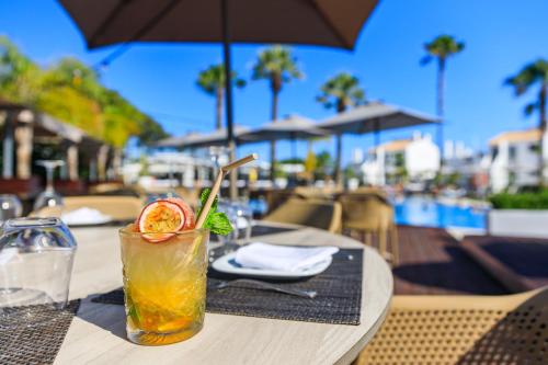 a drink sitting on a table at a restaurant at Apartamentos Honório - Vilamoura in Vilamoura