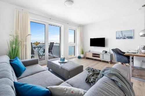 a living room with a couch and a view of the ocean at Marina Sunrise in Olpenitz