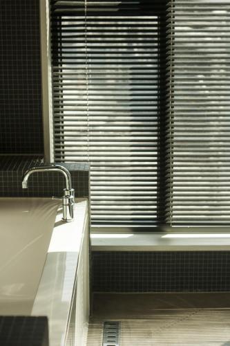 a bathroom with a tub and a window with blinds at 31page in Seoul