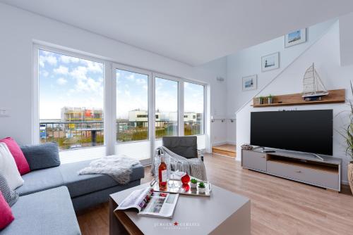 sala de estar con sofá y TV de pantalla plana en Ab ans Meer en Olpenitz