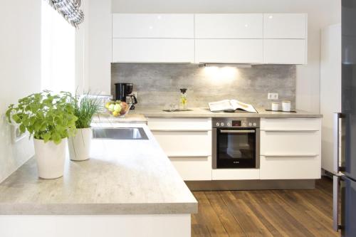 a kitchen with white cabinets and a sink at Penthouse am Glockenturm in Flensburg