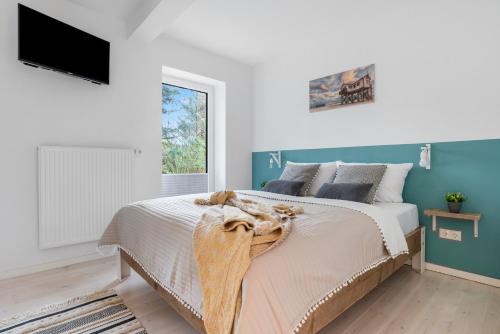 a bedroom with a bed and a tv on the wall at Böe in Sankt Peter-Ording