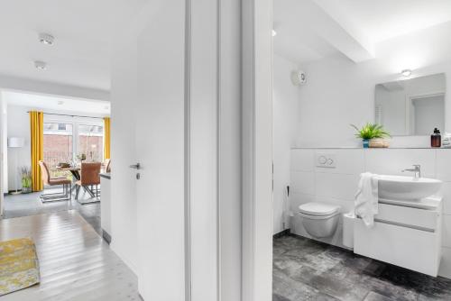 a white bathroom with a sink and a toilet at Böe in Sankt Peter-Ording