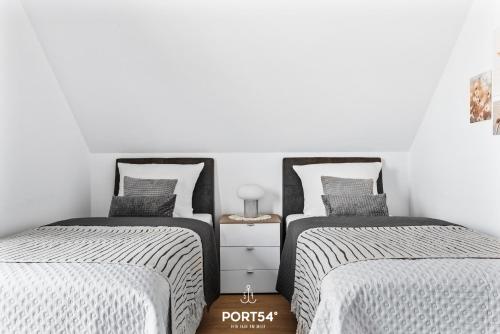 two twin beds in a room with white walls at Lagunen Lodge in Büsum