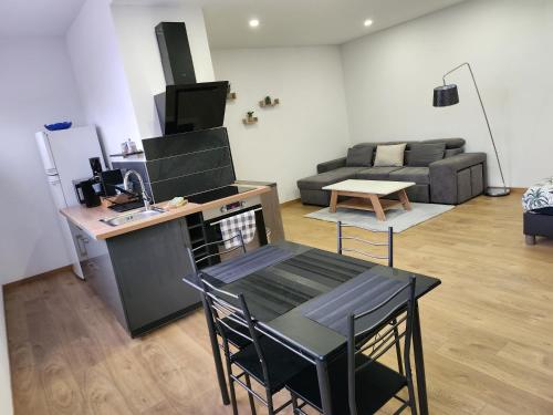 une cuisine et un salon avec une table et des chaises dans l'établissement Joli Studio cosy, à Delle