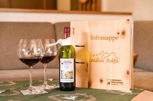 a bottle of wine and two glasses on a table at Landhaus Pichler in Tannheim