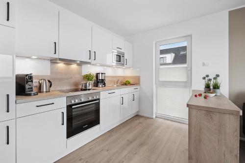 a kitchen with white cabinets and a counter top at Hafen & Meer in Olpenitz