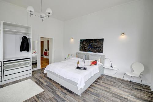 a white bedroom with a bed and a tv at Gesine in Flensburg