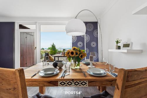 una mesa de comedor con un jarrón de flores. en Wikingeck Schleiblick en Schleswig