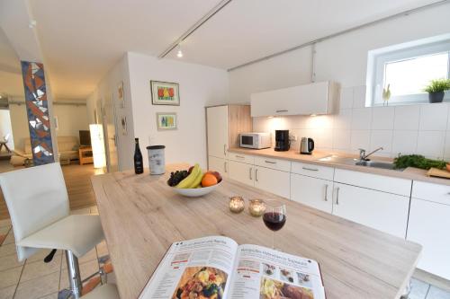 eine Küche mit einem Tisch mit einem Buch und einer Schale Obst in der Unterkunft Stadtloft in Flensburg