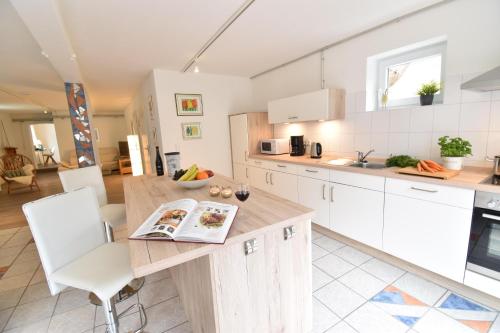 eine Küche mit einem Holztisch und weißen Schränken in der Unterkunft Stadtloft in Flensburg