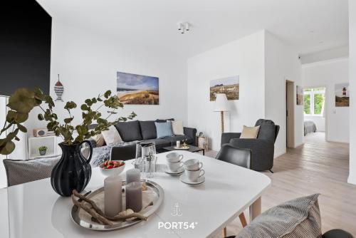 ein Wohnzimmer mit einem weißen Tisch und einem Sofa in der Unterkunft Ferienwohnung Freigeist, App 16 Emmelsbüll in Emmelsbüll-Horsbüll