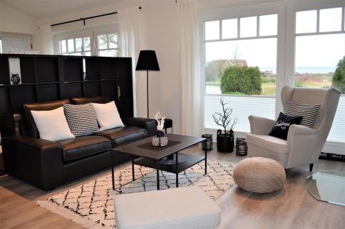 a living room with a couch and a table and chairs at Strandhaus Fördeblick in Langballig
