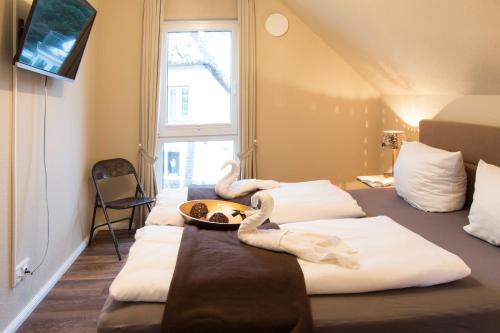 a hotel room with four beds and a window at Strandquartier Solitüde in Flensburg