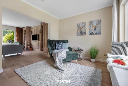 a living room with a green chair and a rug at Reethüs Schleiblick in Selk
