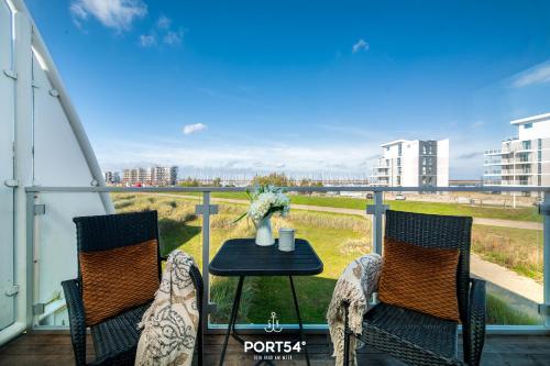 a balcony with two chairs and a table on a balcony at Ferienhaus Ostseelchen Marina Wendtorf in Wendtorf