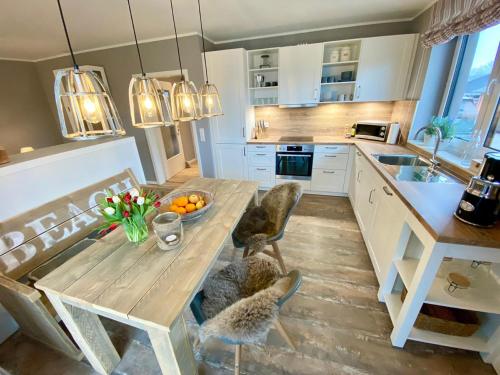 uma cozinha com uma mesa de madeira e algumas cadeiras em Sandpiper em Gelting