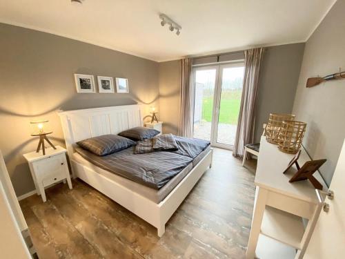 a bedroom with a bed and a large window at Sandpiper in Gelting