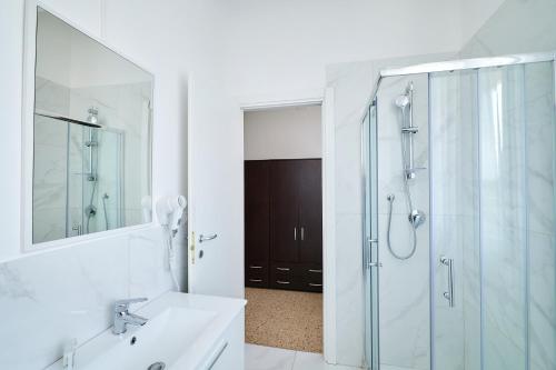 a bathroom with a shower and a sink and a mirror at Soleē, Family Holidays & Hostelling in Cesenatico