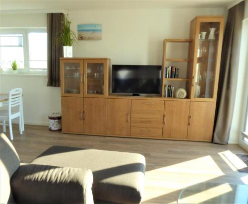 a living room with a large entertainment center with a flat screen tv at FEWO Sterntaucher in Olpenitz