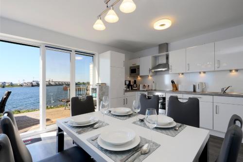 a kitchen and dining room with a table and chairs at Primavera in Olpenitz